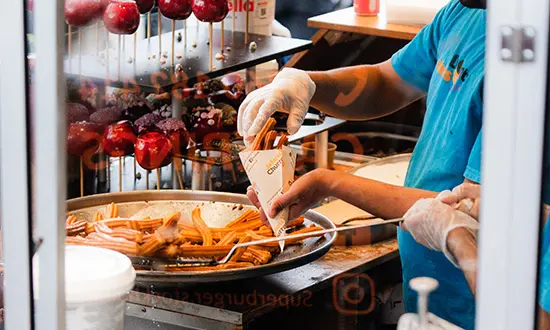 En person serverar churros i en förpackning.